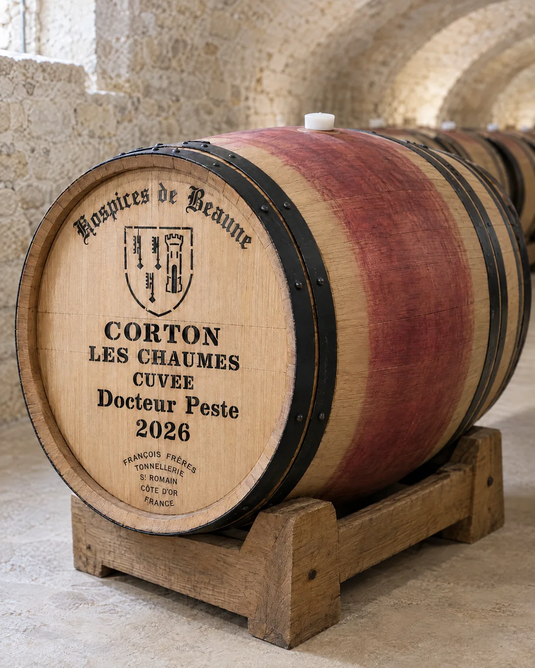 A new Hospices de Beaune barrel stamped Corton Les Chaumes, Cuvée Docteur Peste 2026, its belly washed red