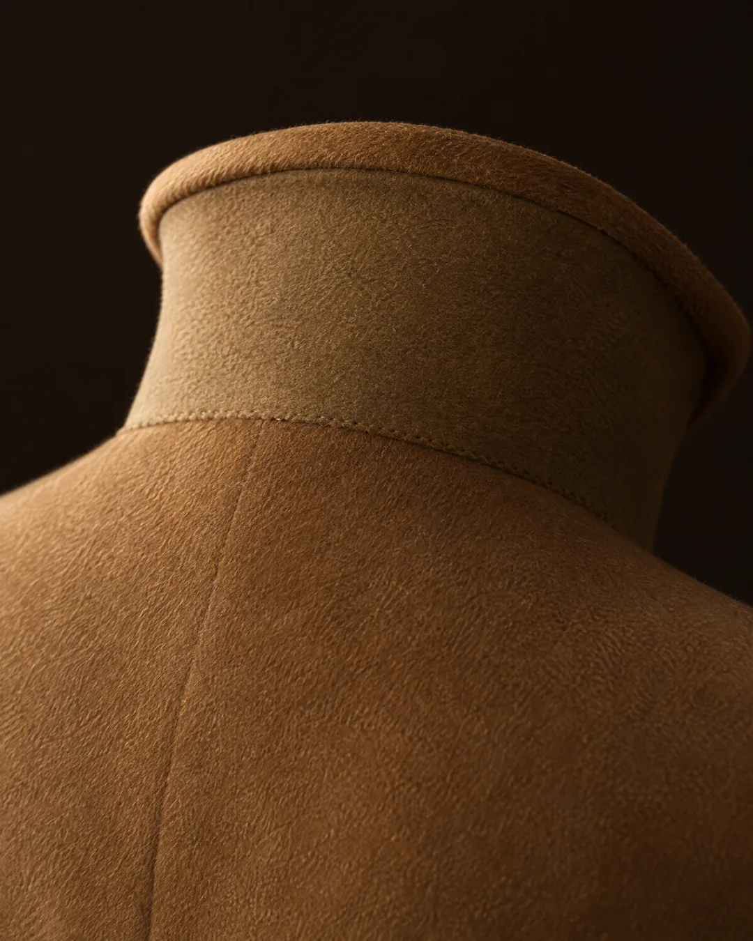 The turned-up collar of a made-to-order vicuña overcoat, its felt undercollar felled by hand