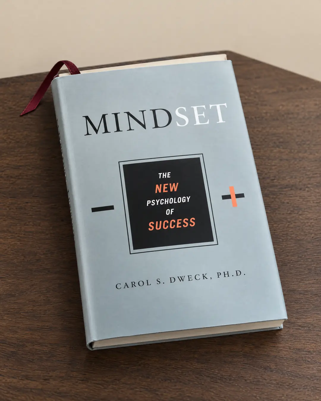 A first printing of Mindset in its gray jacket on oak, an oxblood ribbon marking a page